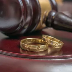 Wedding rings next to a gavel